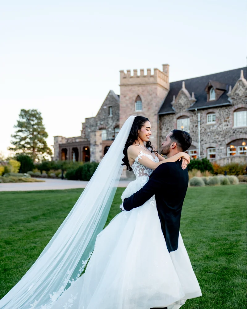 Bride and groom in front of a stone waterfall, her train pooling across the rocks